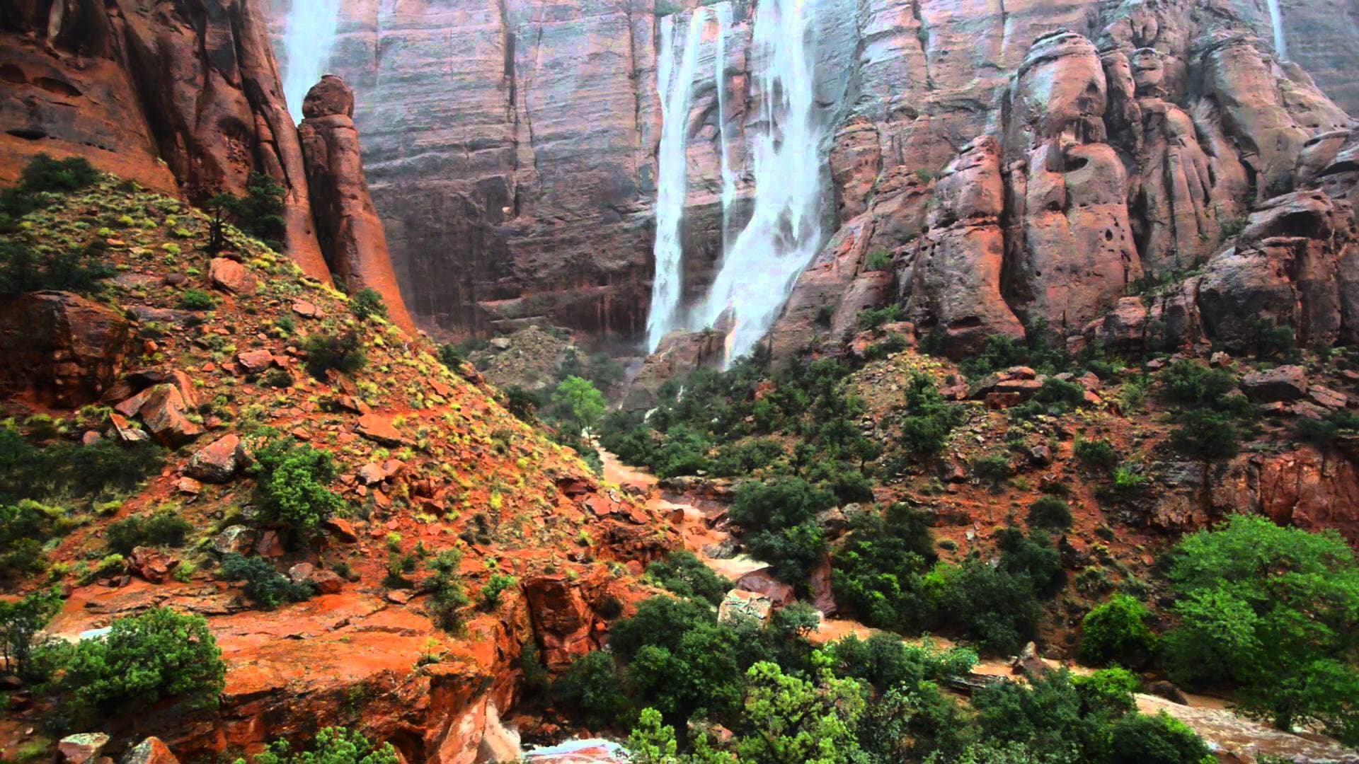 Waterfalls streaming down the sandstone walls of Zion Canyon after seasonal rain
